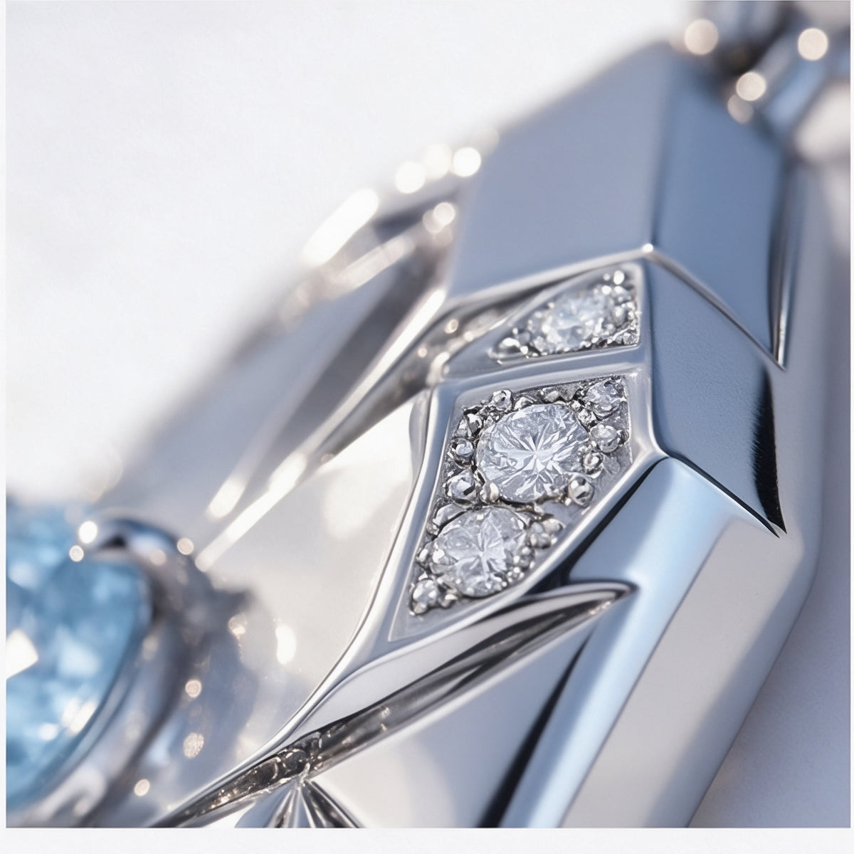 Macro of The Glacier Pendant's frost-set white moissanite accents along a faceted ridge, edged with fine milgrain