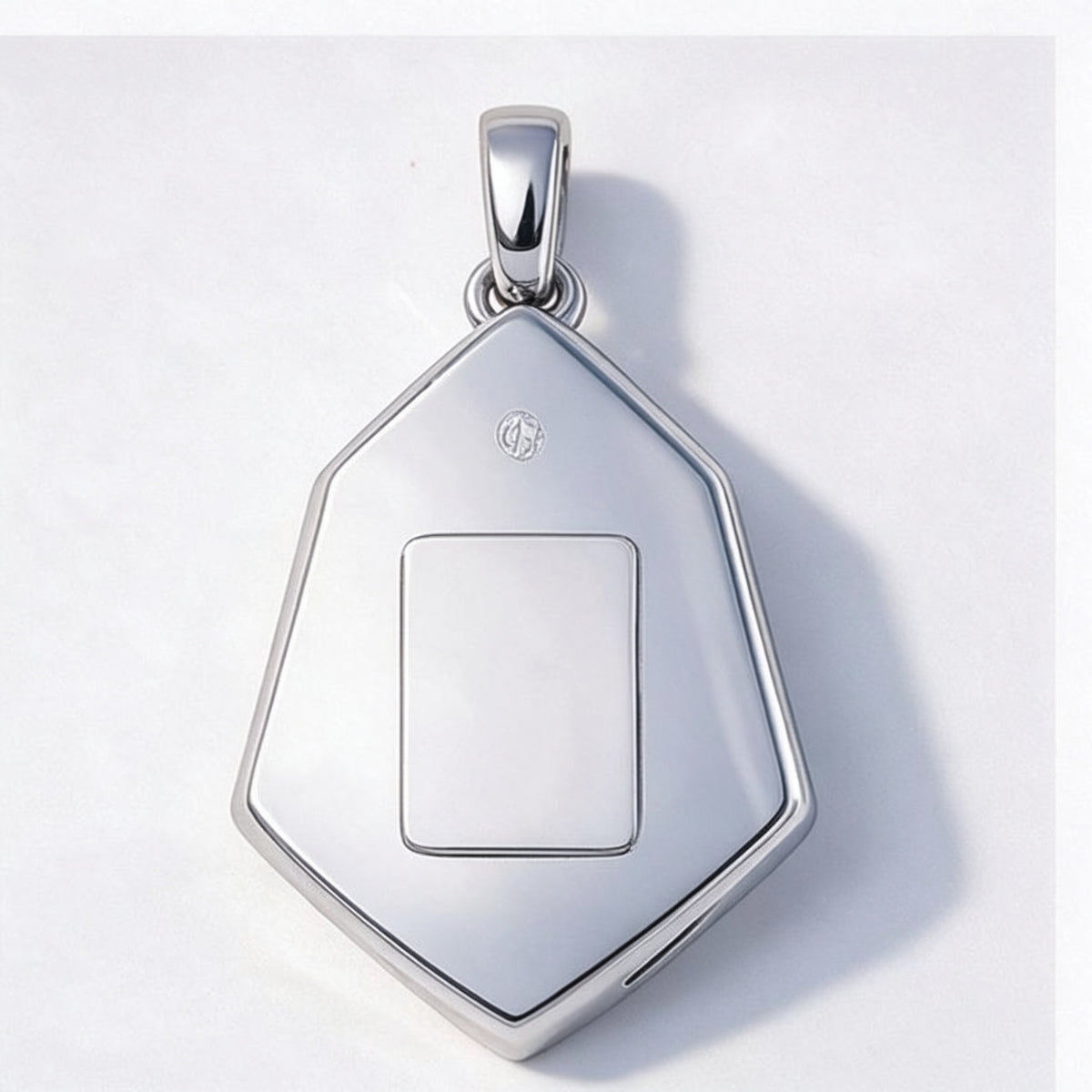 The Glacier Pendant from the back, a polished plane with a rectangular engraving area and a small hallmark